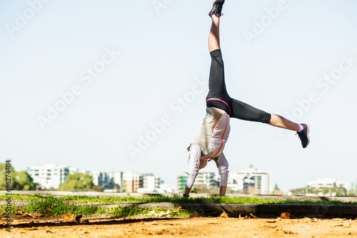 Young fit woman doing simple acrobatics exercise routine in