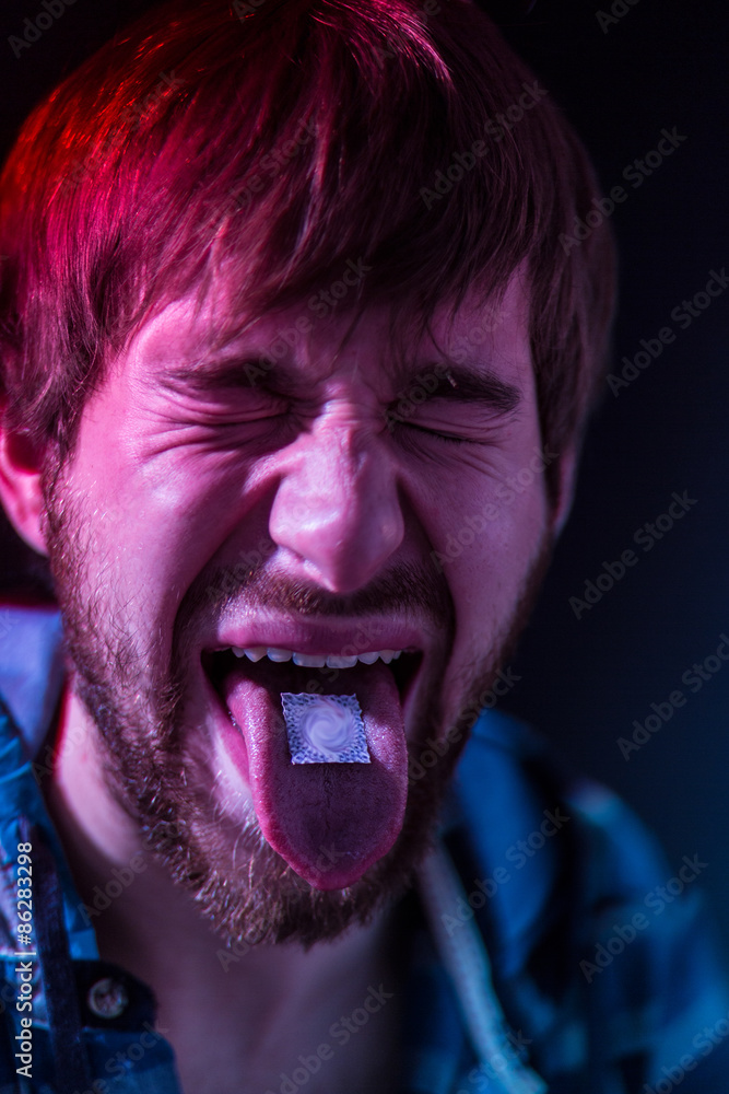 Close-up on junkie man taking LSD Close-up on junkie man taking LSD