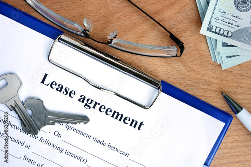 Lease agreement document with money on a wood background