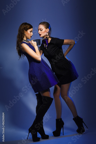 Fashion models posing in blue background