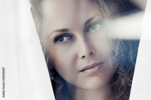 Sad beautiful woman looking out window