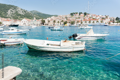 Idyllic Mediterranean ,luxury pleasure boats in Starigrad harbor of historic town with white buildings terracotta tiles around the shore and rolling green hills.,Hvar, Croatia.