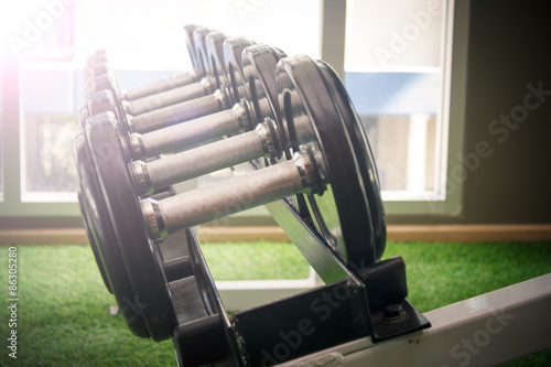 dumbbell in gym - vintage effect and sun flare filter effect
