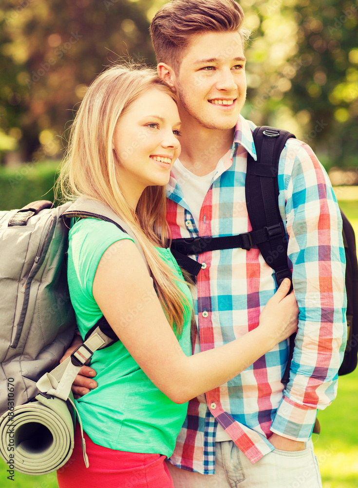 smiling couple with backpacks in nature