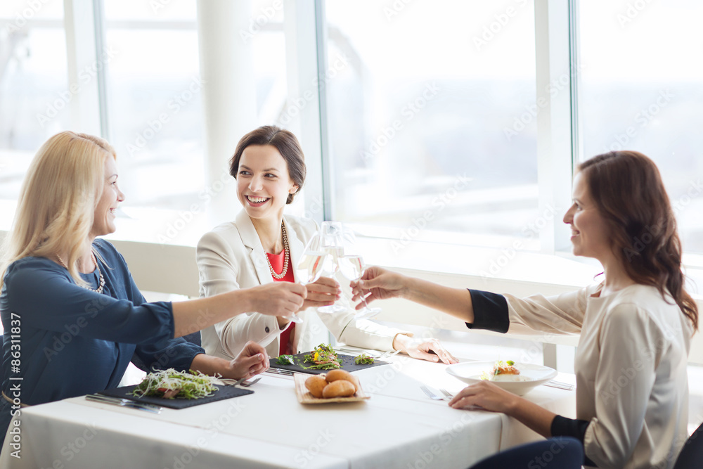 happy women drinking champagne at restaurant