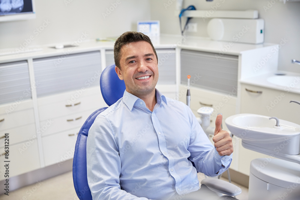 Fototapeta premium happy man showing thumbs up at dental clinic