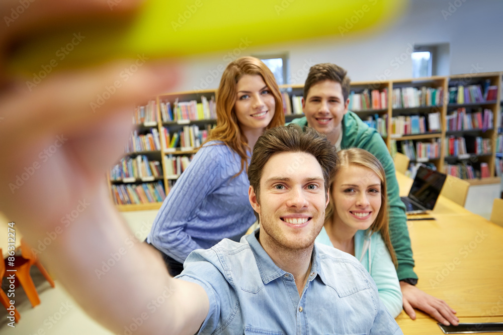 Fototapeta premium students with smartphone taking selfie in library
