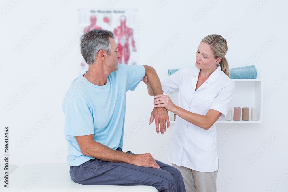 Obraz premium Doctor stretching a man arm