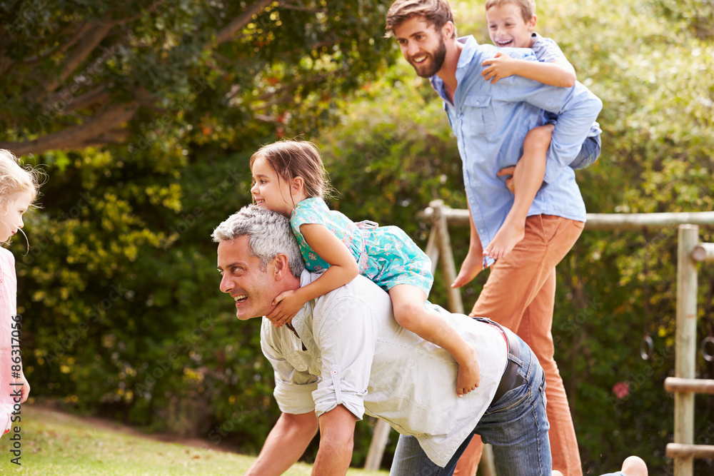 Fototapeta premium Two men playing with kids in a garden