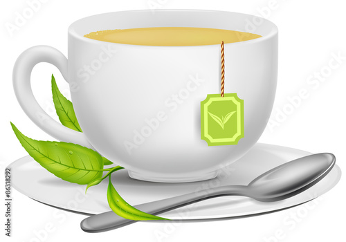 A cup of green tea with tea leaves and a spoon.