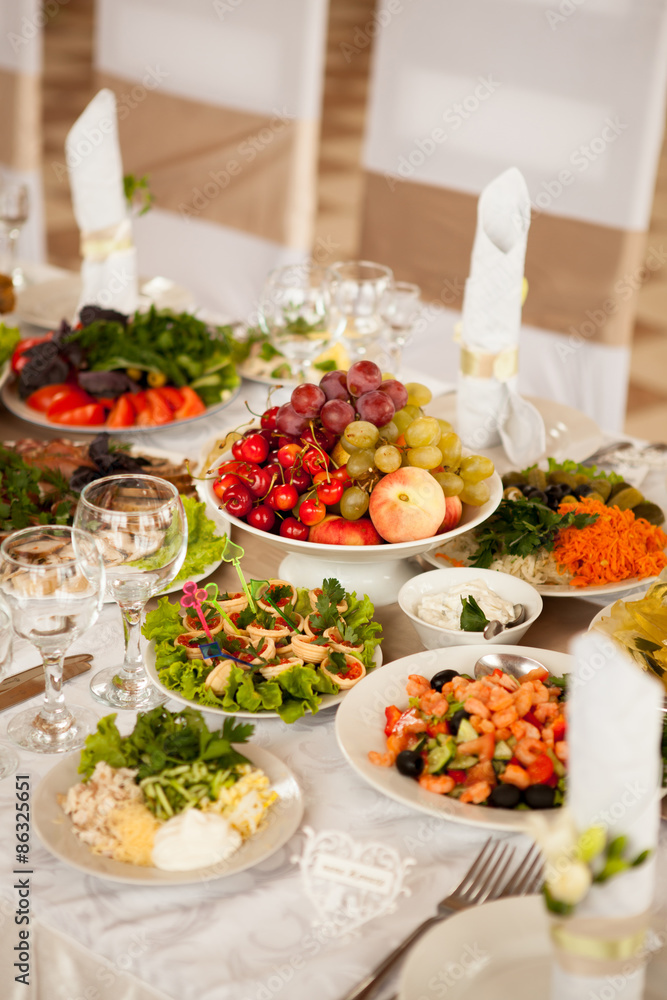 Festive table with fruit and snacks, salads