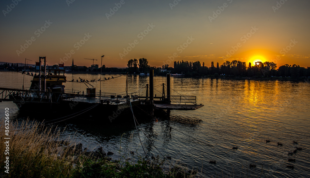 Fototapeta premium Bootssteg im Sonnenaufgang am Rheinufer in Mainz