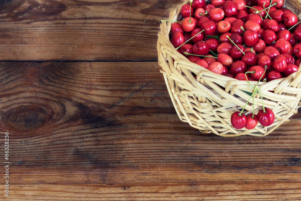 Ripe organic homegrown cherries in a basket, on wooden background Ripe organic homegrown cherries in a basket, on wooden background