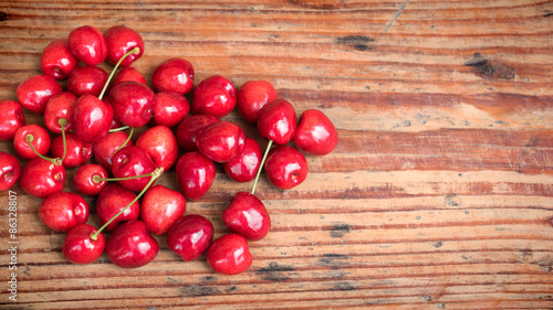Ripe organic homegrown cherries on wooden background photo
