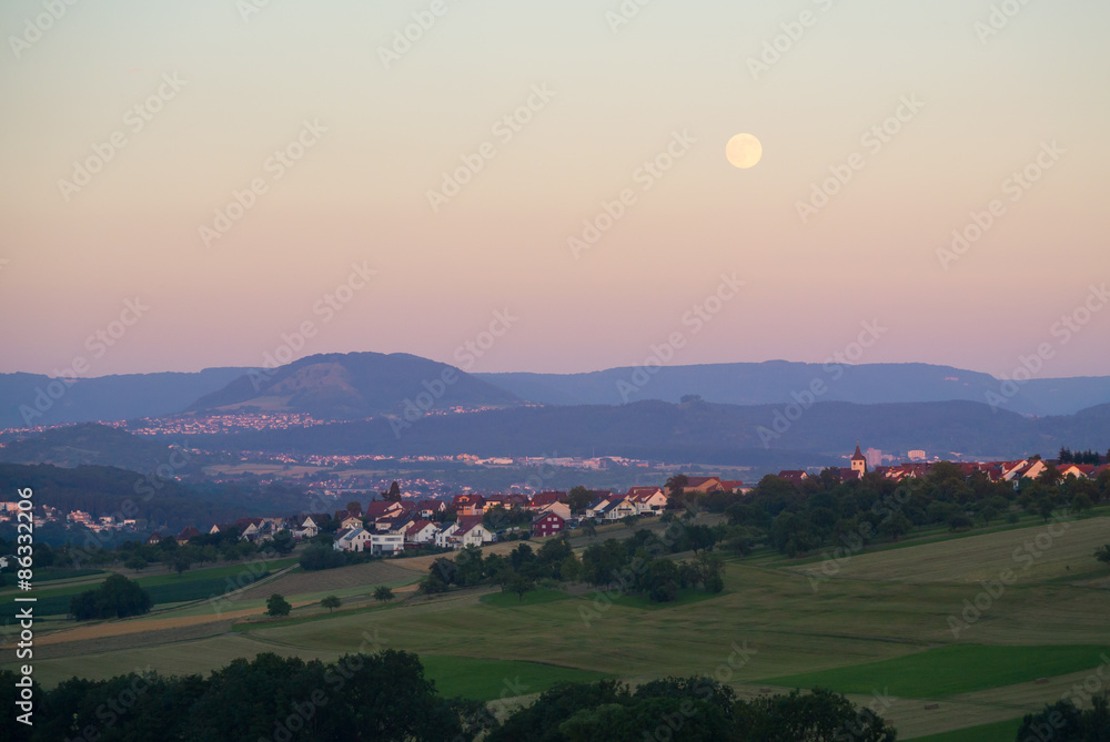 Fototapeta premium Altenriet mit Albtrauf / Jusi im Abendlicht + Mond
