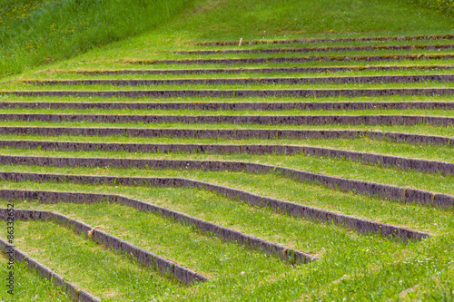Plurality of layers overgrown with grass in old summer theater.
