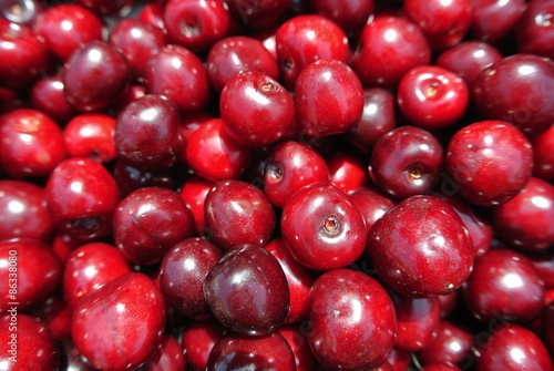 Closeup of a pile of ripe red cherries. Concept of organic farming; fresh, natural, unprocessed fruit: clean eating; paleo diet.