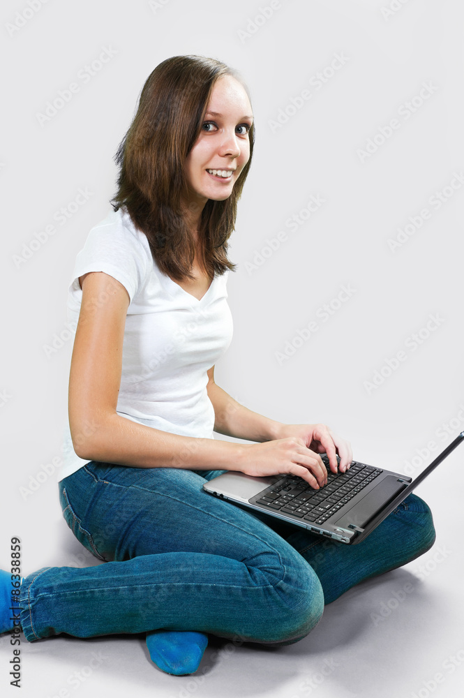 Student young girl with laptop computer on gray background. color image Student young girl with laptop computer on gray background. color image