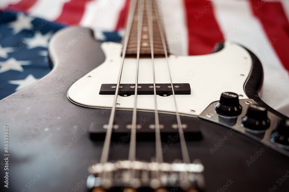 Fototapeta premium Vintage Bass guitar body on american flag background. selective focus image with shallow depth of field
