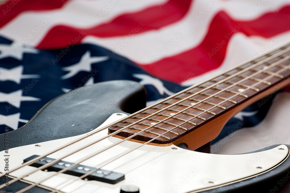 Fototapeta premium Vintage Bass guitar body on american flag background. selective focus image with shallow depth of field