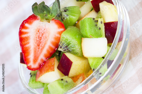 Fruit salad in white plate on tablecloth