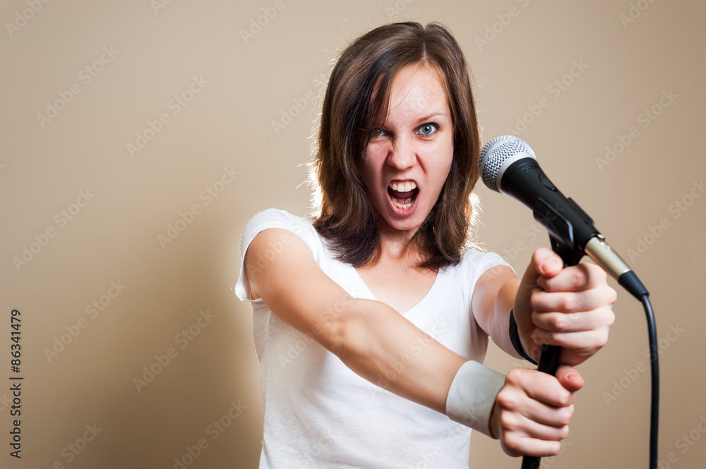 Young adult girl singing with microphone. color image Young adult girl singing with microphone. color image