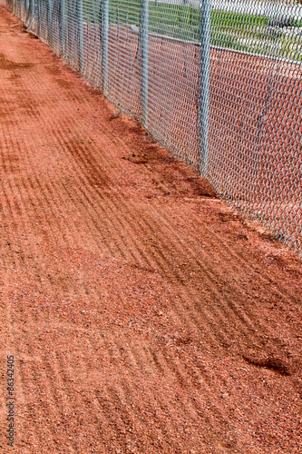 Raked warning track near the chain link fence at a softball field in New Mexico © karagrubis