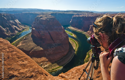 Young woman taking photograph of panoramic view of Horseshoe Bend at Utah, USA