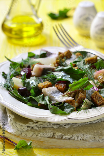 Salad with fresh organic beetroot,herrings and rye croutons. photo