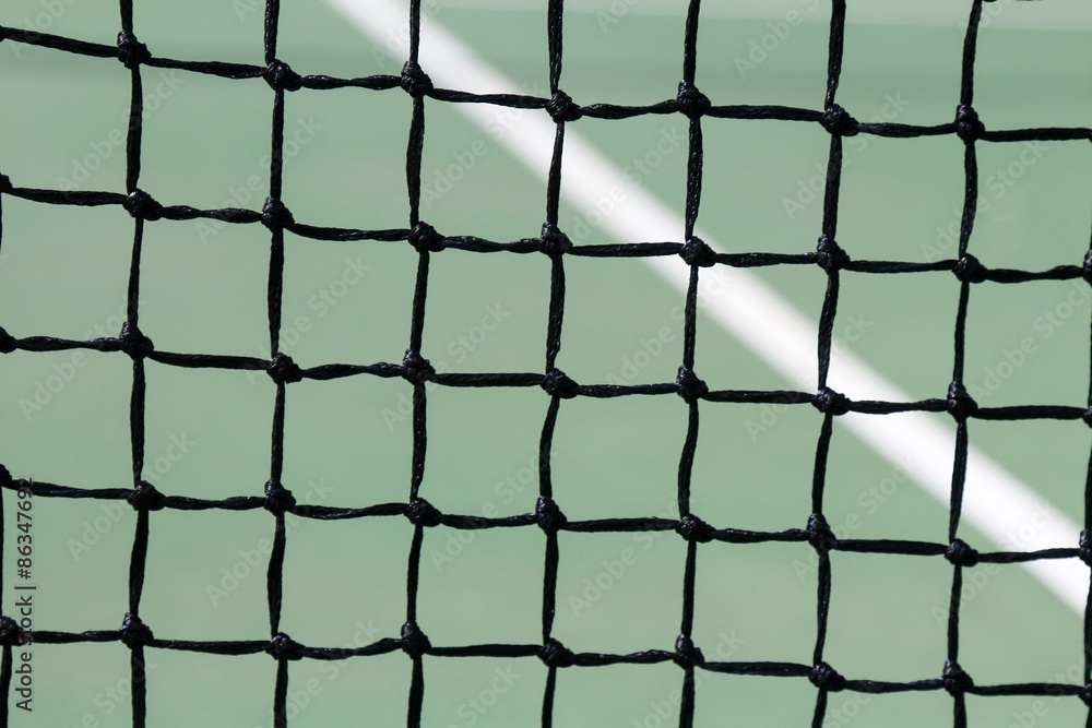 Fototapeta premium Full frame close up image of a tennis court net with green court and white line 