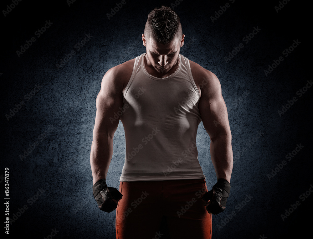 handsome young man after a workout on a dark background handsome young man after a workout on a dark background