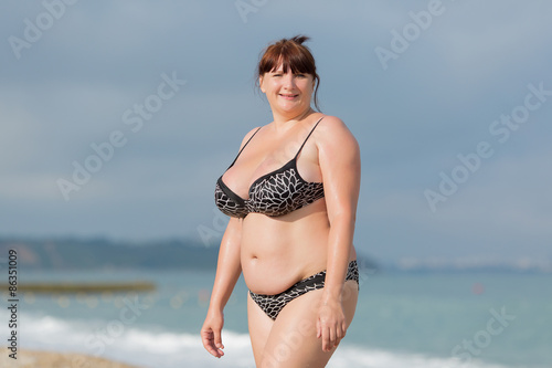 Fotografie Overweight young woman at the sea