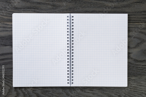 blank notepad with chequered pages on gray wood table
