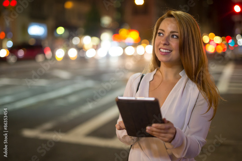 Young caucasian woman in city using tablet pc computer