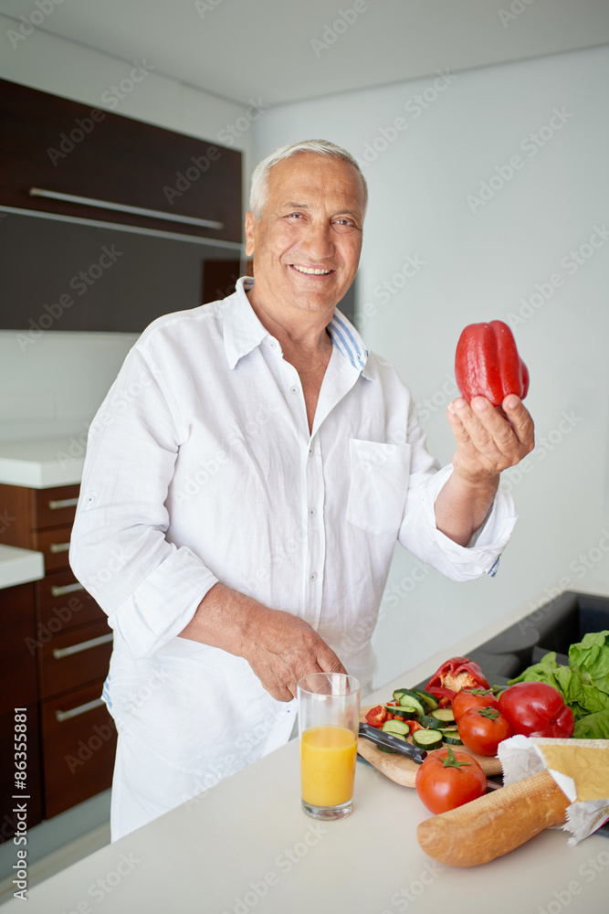 man cooking at home preparing salad in kitchen man cooking at home preparing salad in kitchen