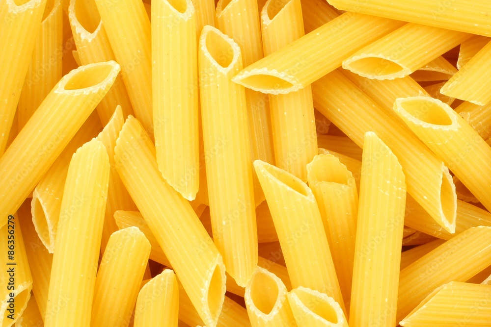 Full background of dry uncooked penne pasta Full background of dry uncooked penne pasta