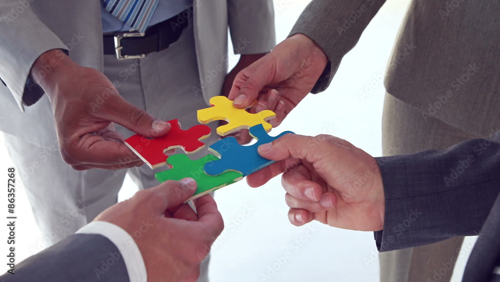 Business colleagues holding pieces of puzzle Business colleagues holding pieces of puzzle