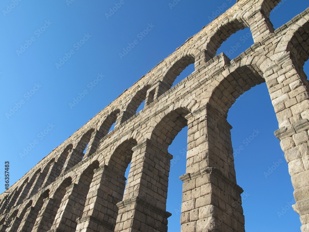 Roman aqueduct in Segovia, Spain under clear blue sky