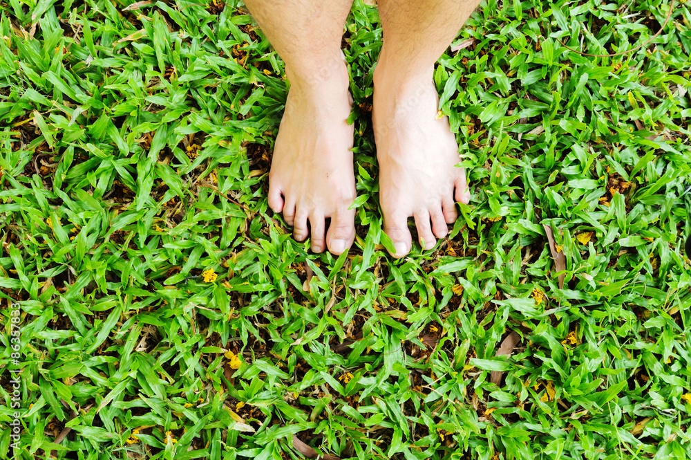 Man feet on green grass background Man feet on green grass background