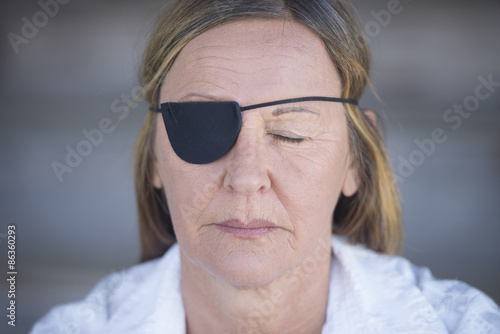 Foto Mature woman with eye patch portrait