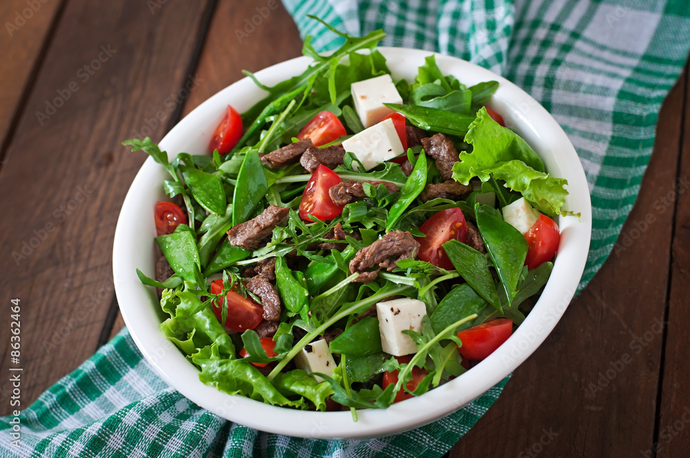 Salad with veal slices, arugula, tomatoes and feta cheese
