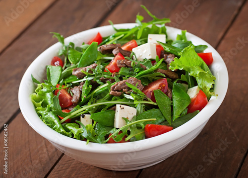Salad with veal slices  arugula  tomatoes and feta cheese