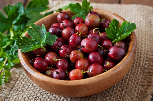 Red gooseberries in a wooden bowl