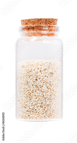 Sesame seeds in a glass bottle with cork stopper, isolated on wh