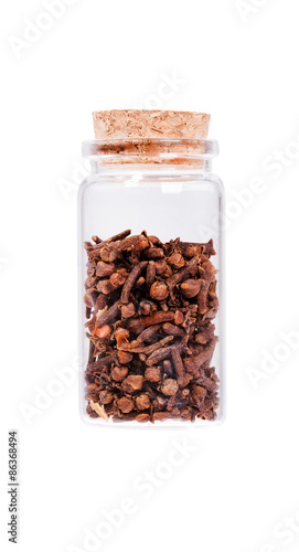 Dried cloves in a glass bottle with cork stopper, isolated on wh