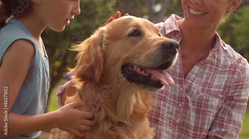Mother and her daughter with their dog in the park