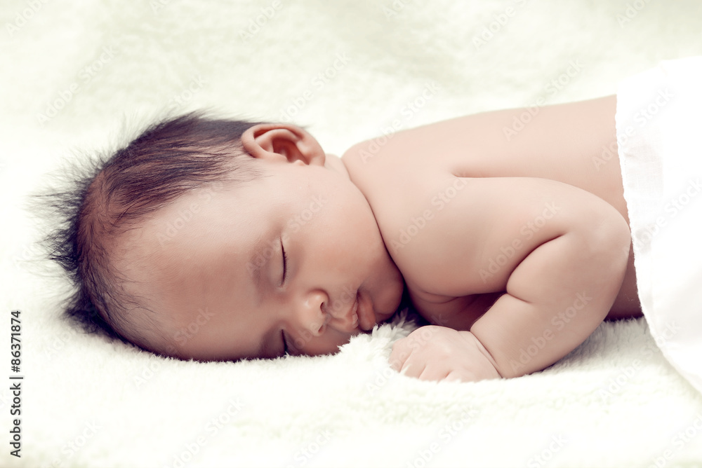 Peaceful baby lying on a bed while sleeping in a bright room Peaceful baby lying on a bed while sleeping in a bright room