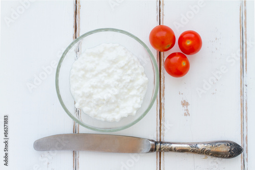 Cottage cheese in a bowl on a vintage wood background