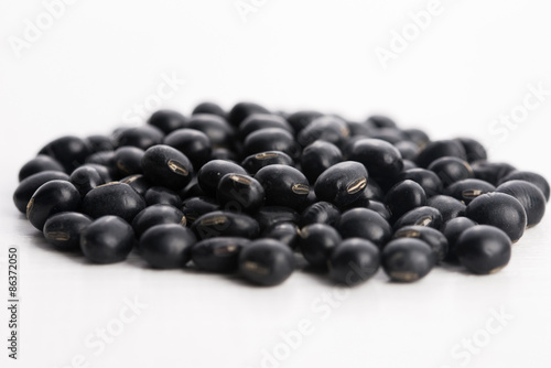 A lot of black soybeans on wooden background