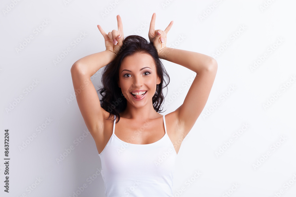 Fototapeta premium Cheerful young girl is making faces with fun